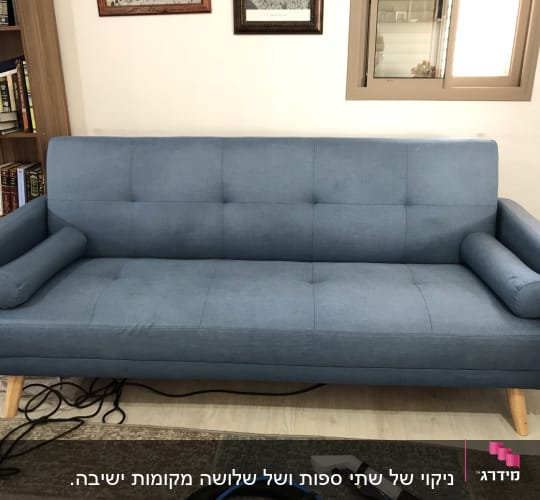 ספה כחולה עם מכשיר ניקוי על הרצפה